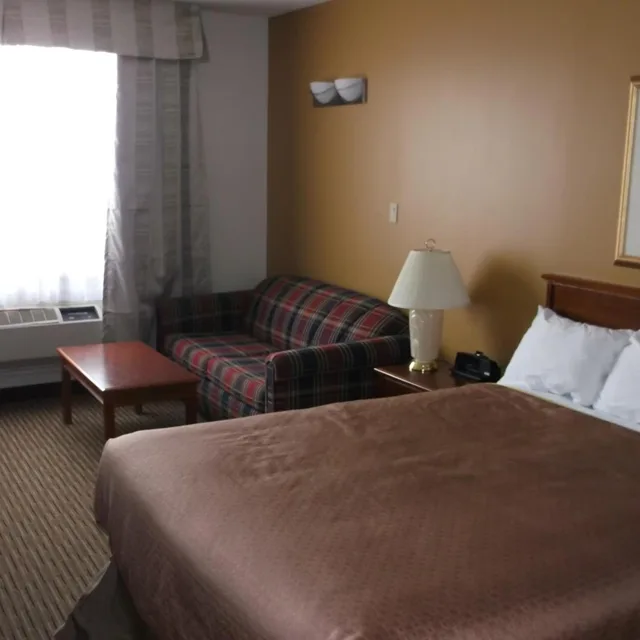 غرفة بسرير كوين مع أريكة، Foxwood Inn and Suites 1/2