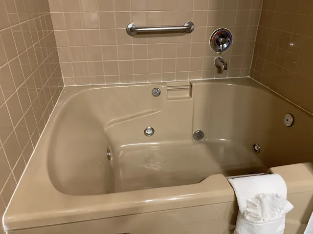 غرفة بسرير كوين مع أريكة بحوض جاكوزي، Coachman Inn Suites 2/2