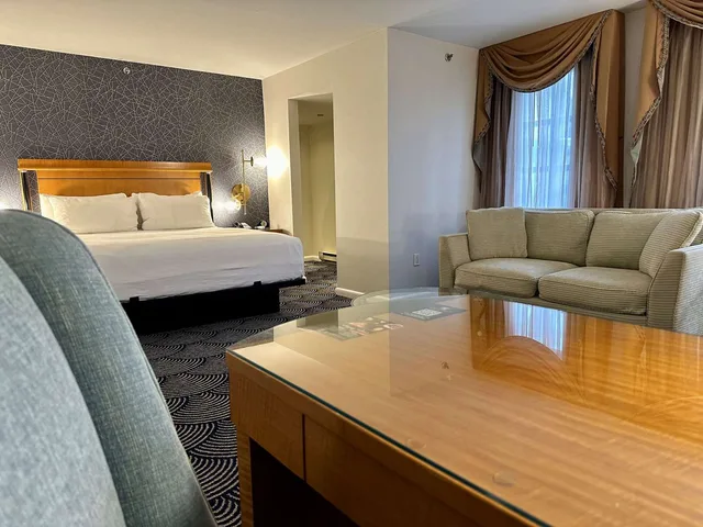 غرفة بسرير كينج مع أريكة بمطبخ صغير، Inn At Great Neck 4/5