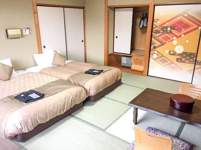 غرفة يابانية تقليدية بسريرين منفصلين وفرشتي فوتون بأرضية تاتامي، LiVEMAX Resort Kaga-Yamashiro 1/2