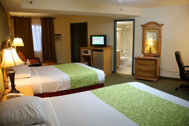جناح بسريرين كوين بغرفة نوم واحدة مع أريكة بمطبخ صغير، Americas Best Value Inn Suites Anchorage Airport 2/2