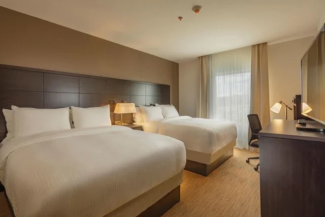 غرفة بسرير كينج وسريرين مزدوجين بغرفتي نوم، Staybridge Suites Saltillo 1/1