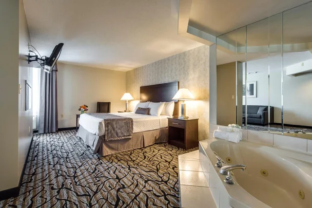 جناح ديلوكس بسرير كينج بمنطقة جلوس بحوض جاكوزي، Monte Carlo Inn Oakville Suites 2/7