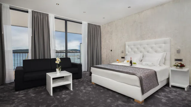 غرفة بسرير كينج بإطلالة على البحر بشرفة مع أريكة، Marina Baotic Apartments 1/4