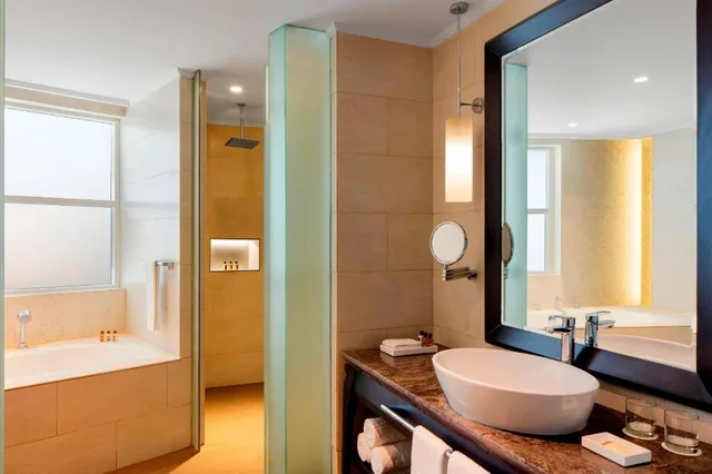 جناح جونيور بسرير كينج بإطلالة على المسبح بشرفة مع دخول صالة النادي، Sheraton Sharjah Beach Resort Spa 2/2
