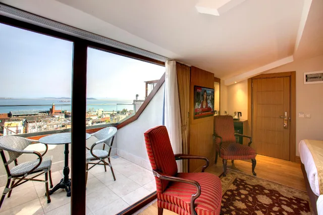 غرفة ديلوكس بسرير كينج وسرير فردي بإطلالة على البحر بشرفة، Acra Hotel 1/1