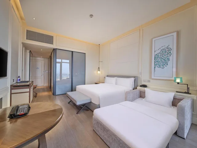 غرفة ديلوكس بسرير كينج بإطلالة على البحر بشرفة مع أريكة، Hilton Dalian Golden Pebble Beach Resort 1/6