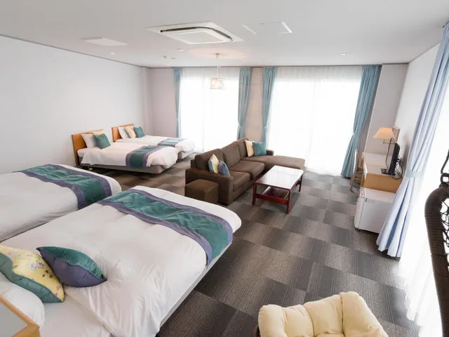 غرفة رباعية بثلاثة أسرّة مع أريكة، Hotel Caretta Amami 4/8