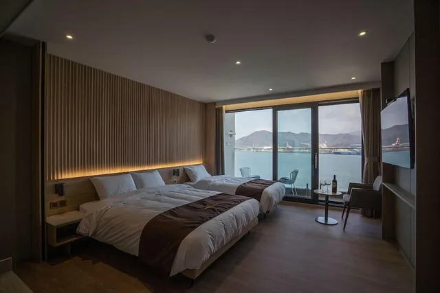 غرفة ديلوكس بسرير كوين وسرير فردي بإطلالة على البحر، Masan Tourist Hotel 1/1