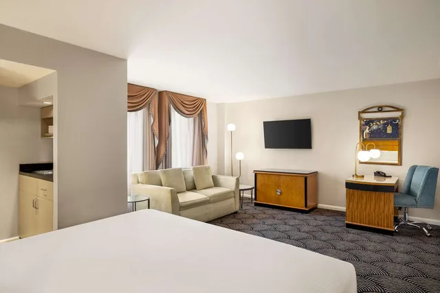 غرفة بسرير كينج مع أريكة بمطبخ صغير، Inn At Great Neck 1/5