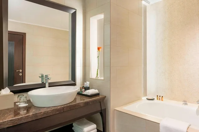 غرفة ديلوكس بسريرين مزدوجين بإطلالة جزئية على البحر، Sheraton Sharjah Beach Resort Spa 3/4