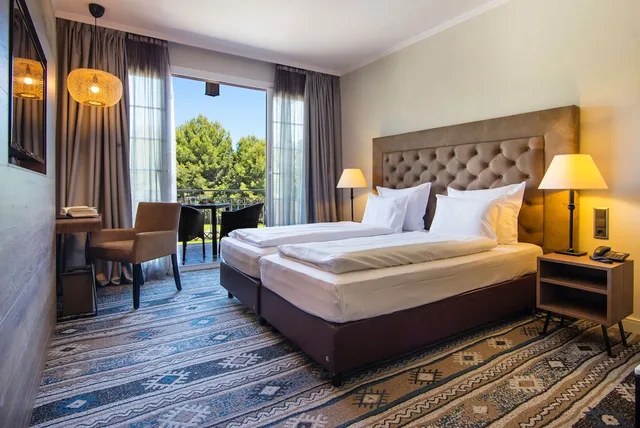 غرفة بسريرين منفصلين بإطلالة على المسبح مع أريكة، Lindner Golf Resort Portals Nous 1/9