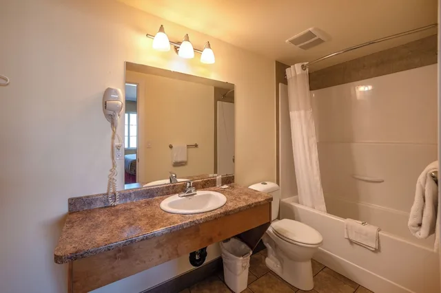 جناح بسرير كوين بغرفة نوم واحدة مع أريكة بمطبخ، Sahara Courtyard Inn Penticton 7/8