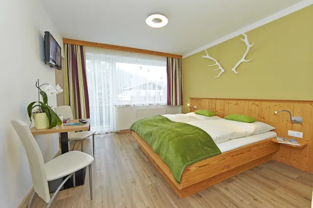 غرفة كومفورت عائلية رباعية بسرير كينج وسرير فردي بإطلالة على الجبل بشرفة مع أريكة، Landhaus Gitti Hotel Garni 1/7