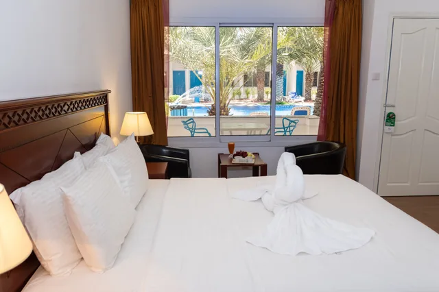 غرفة ديلوكس بسرير كينج بإطلالة على المسبح بغرفة نوم واحدة، Fujairah Hotel and Resort 1/2