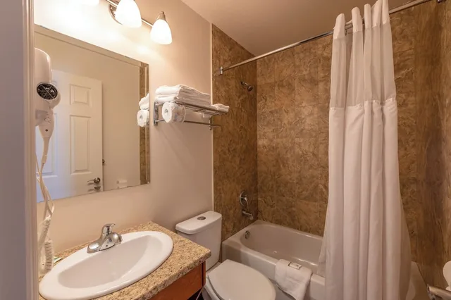 جناح بسرير كوين بغرفة نوم واحدة مع أريكة بمطبخ، Sahara Courtyard Inn Penticton 5/8