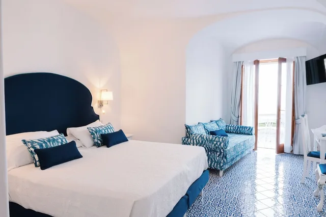 غرفة ديلوكس ثلاثية بسرير كينج وسرير فردي بإطلالة على البحر بغرفة نوم واحدة، Hotel Conca d'Oro 1/6