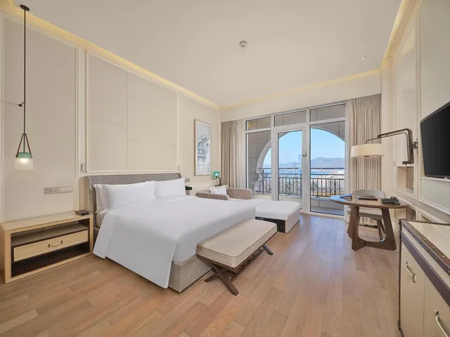 غرفة ديلوكس بسرير كينج بإطلالة على البحر بشرفة مع أريكة، Hilton Dalian Golden Pebble Beach Resort 4/6