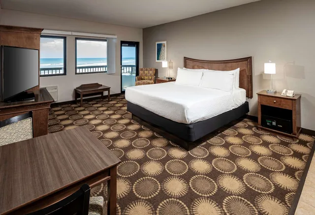 غرفة بسرير كينج بإطلالة على البحر بشرفة بمنطقة جلوس، New Smyrna Beach Hotel & Suites 1/2