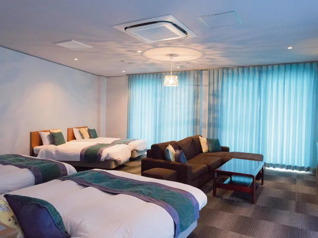 غرفة رباعية بثلاثة أسرّة مع أريكة، Hotel Caretta Amami 7/8
