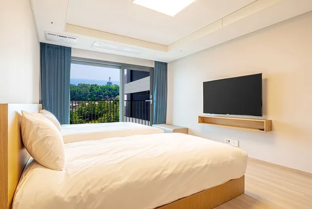 غرفة ديلوكس بسريرين منفصلين وسرير كوين وسرير فردي بإطلالة جزئية على البحر، Sokcho I Park Suite Hotel and Resort 3/8