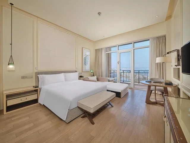 غرفة ديلوكس بسرير كينج بإطلالة على البحر بشرفة مع أريكة، Hilton Dalian Golden Pebble Beach Resort 3/6
