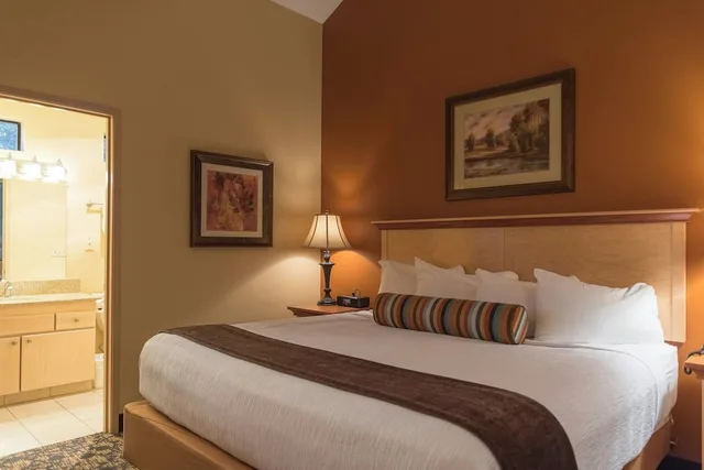 جناح ديلوكس بسرير كينج وسرير كوين بغرفتي نوم مع أريكة، Whispering Woods Resort 1/3